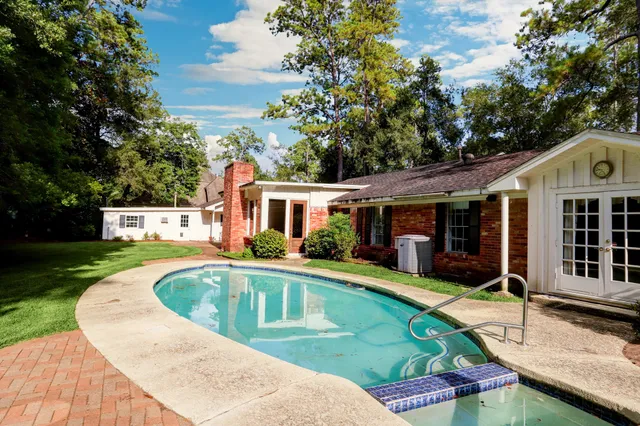 a view of a house with swimming pool and a yard