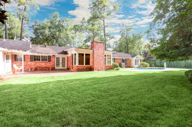 a front view of a house with a garden and trees