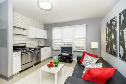 a kitchen with stainless steel appliances granite countertop a stove top oven a sink and white cabinets