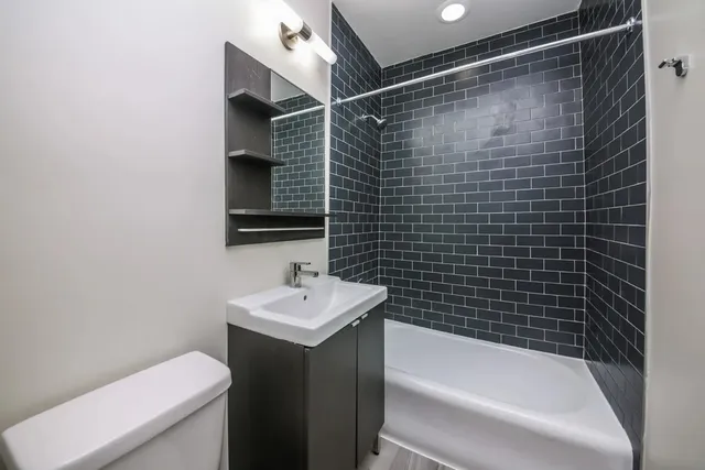 a bathroom with a sink mirror toilet and bathtub