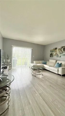 a kitchen with granite countertop a refrigerator a stove a sink dishwasher and white cabinets with wooden floor