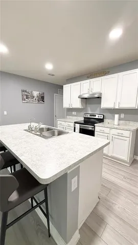 a kitchen with stainless steel appliances granite countertop a table chairs sink and cabinets