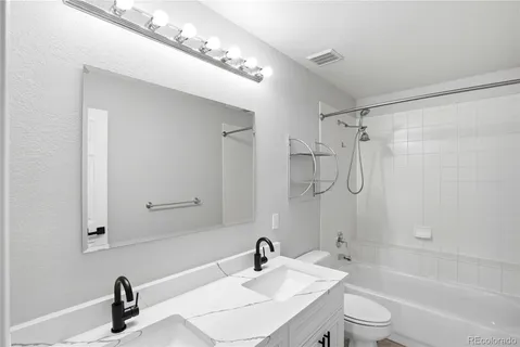 a bathroom with a sink a toilet and a large mirror