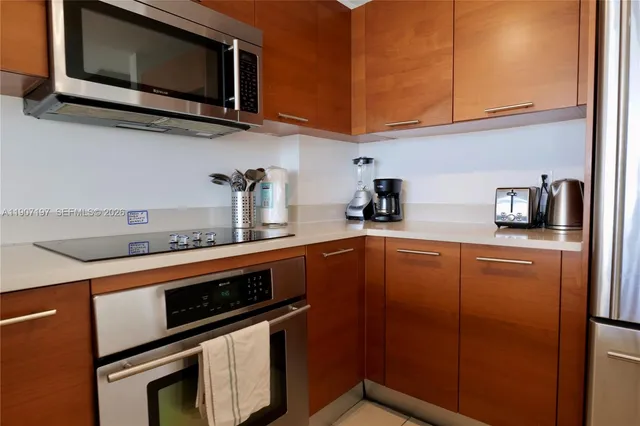 a kitchen with stainless steel appliances a stove microwave and sink