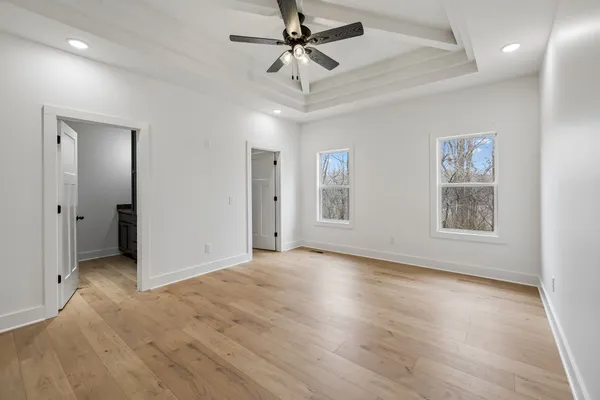 a view of an empty room with a window and a ceiling fan