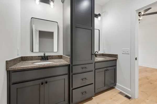 a bathroom with a granite countertop sink and a mirror