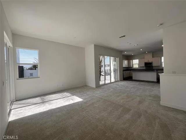 a view of a big room with windows and a kitchen