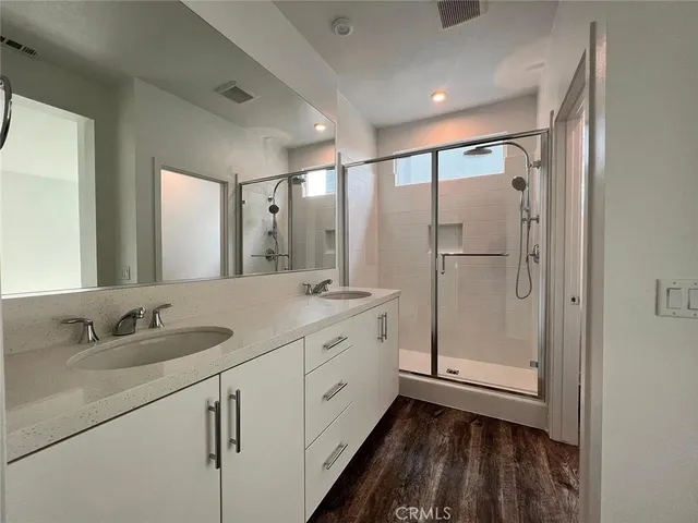 a bathroom with a double vanity sink mirror and shower