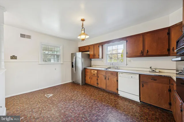 a kitchen with granite countertop a sink cabinets stainless steel appliances and a window