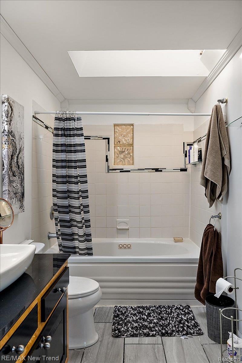 1450 Lenox Road Bloomfield Hills, MI 48304 - Photo 57 of 79 Skylight feature, built-in bathtub, white subway tile surround, wood-finish tile flooring, vanity with countertop and vessel sink
