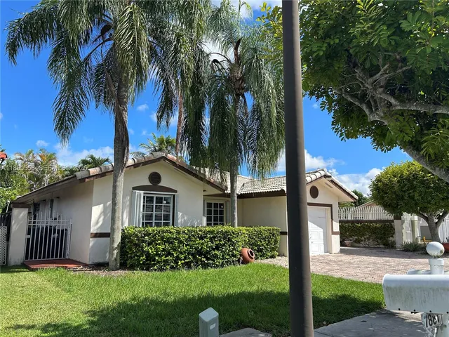 a front view of a house with a garden and yard