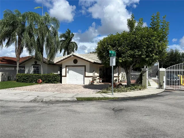 a front view of a house with palm trees