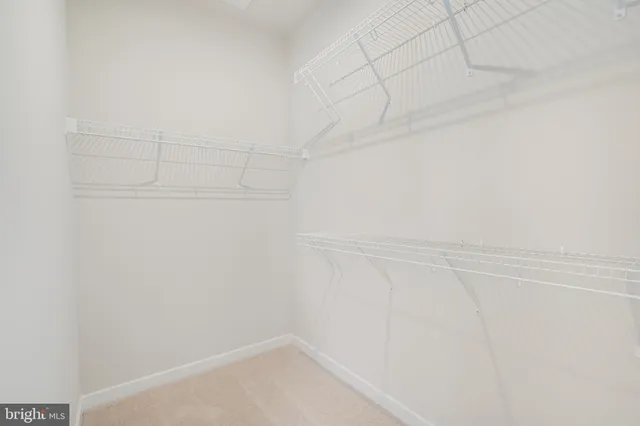 a bedroom with bed and a large mirror next to a window