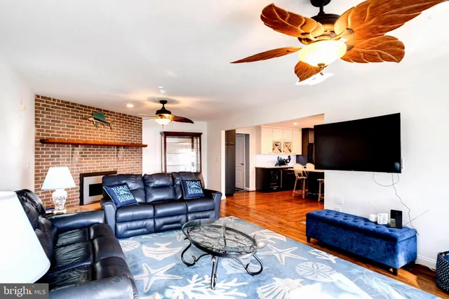 a balcony and dining room with furniture wooden floor and a chandelier