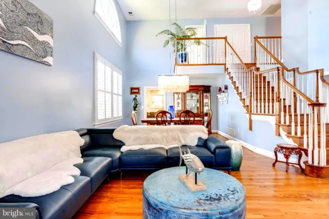a view of a dining room and livingroom with furniture a rug and wooden floor