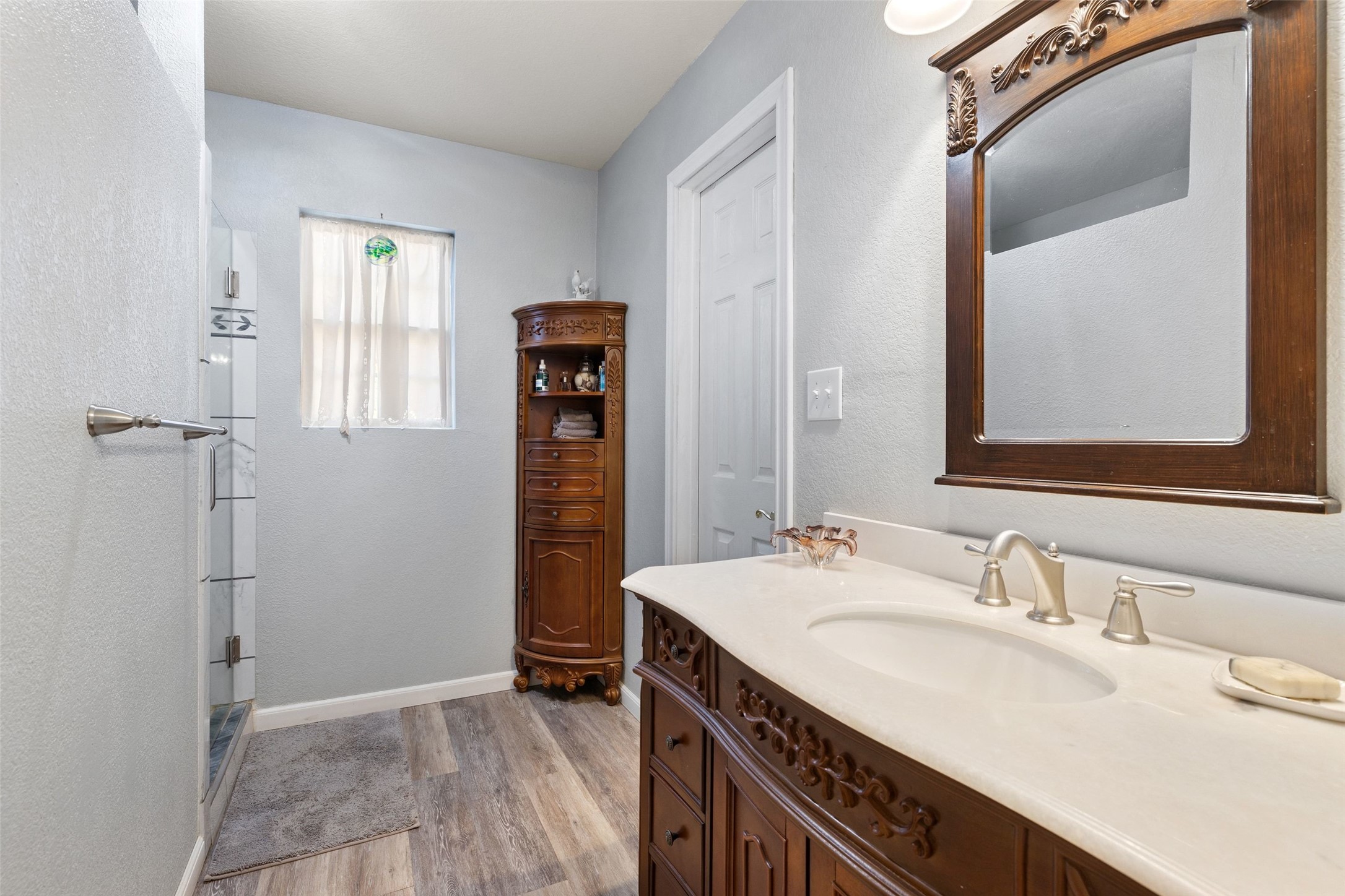 399 Upper Elgin River Road Elgin, TX 78621 - Photo 18 of 39 Bathroom with vanity, light wood-type flooring, and a stall shower