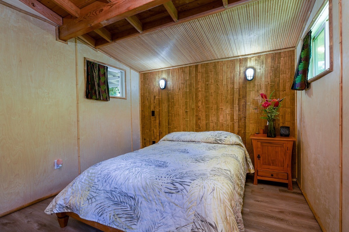 4680 Apopo Road Kapaa, HI 96746 - Photo 14 of 20 a bedroom with a bed and wooden floor
