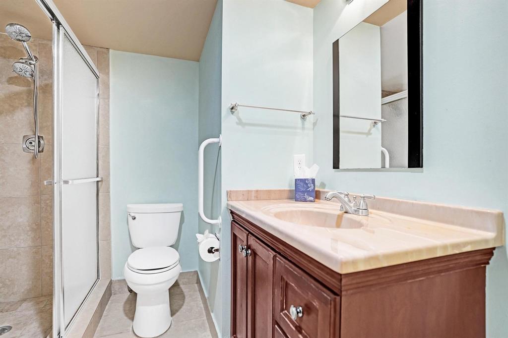 1005 Lincoln A, Unit 1005 Boca Raton, FL 33434 - Photo 14 of 33 a bathroom with a sink a toilet and a mirror