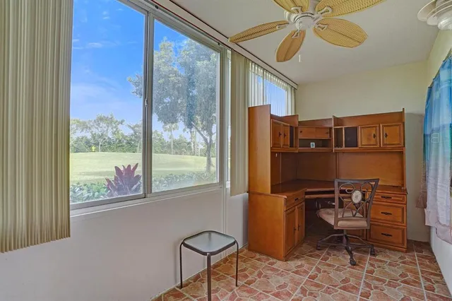 a view of a workspace with furniture and a window