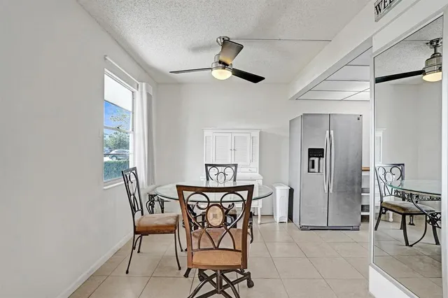 a view of a dining room with furniture and a chandelier fan