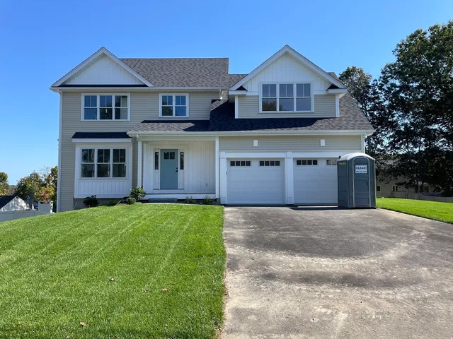 a front view of a house with a yard and garage