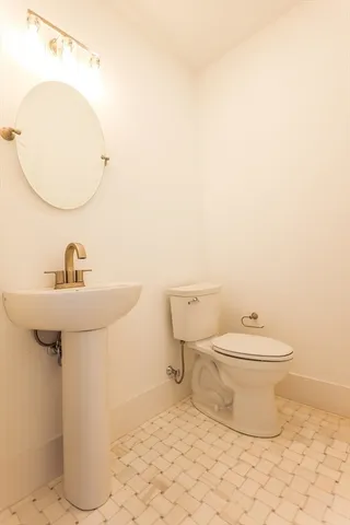 a bathroom with a toilet sink and mirror