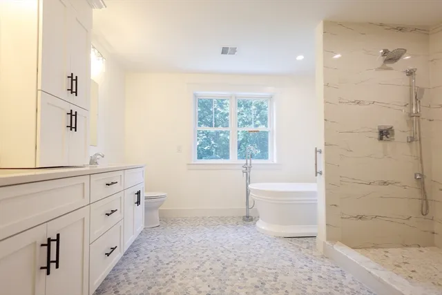 a bathroom with a bathtub sink and mirror