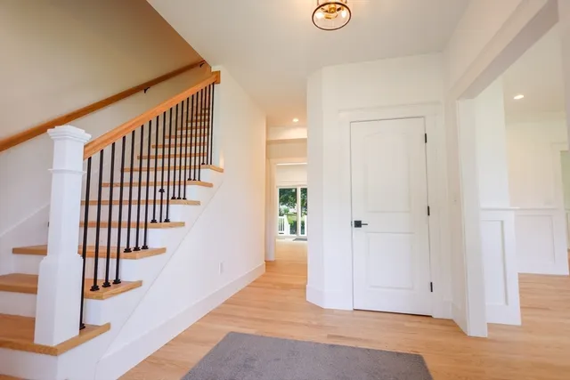 a view of a hallway with wooden floor and entryway
