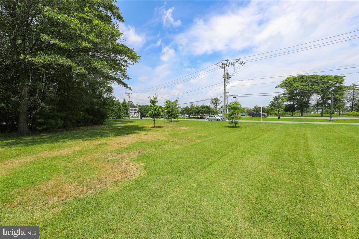 312 Garfield Parkway Bethany Beach, DE 19930 - Photo 15 of 16 a view of a big building with a big yard and large trees