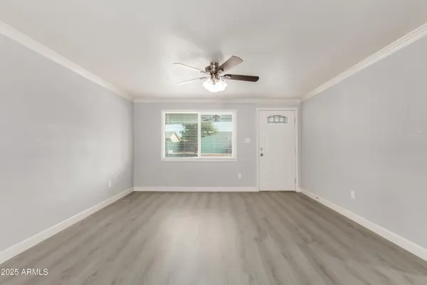 an empty room with wooden floor and windows