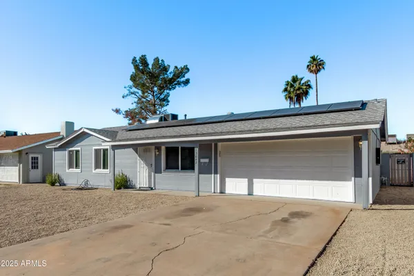 a view of a house with a yard and potted plants