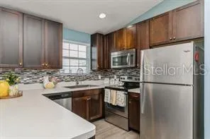 a kitchen with kitchen island granite countertop a sink stove and refrigerator