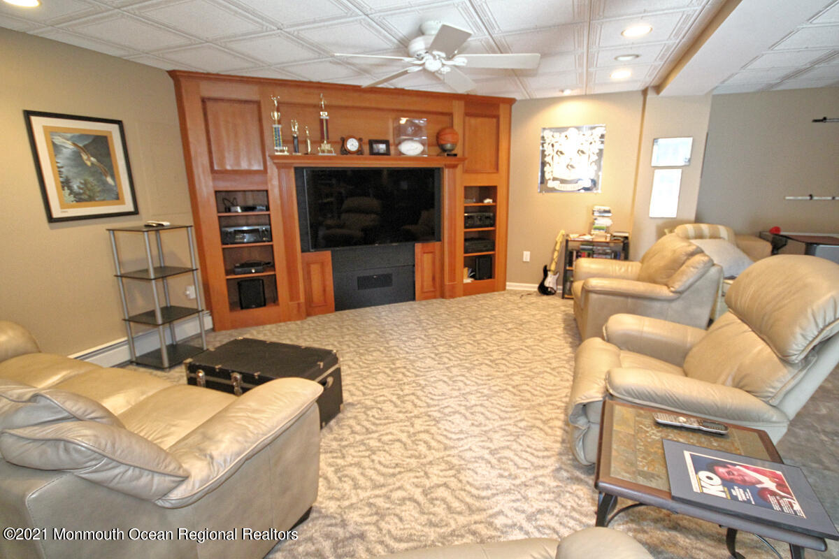 33 Maher Road Freehold, NJ 07728 - Photo 31 of 46 a living room with furniture a flat screen tv and a fireplace