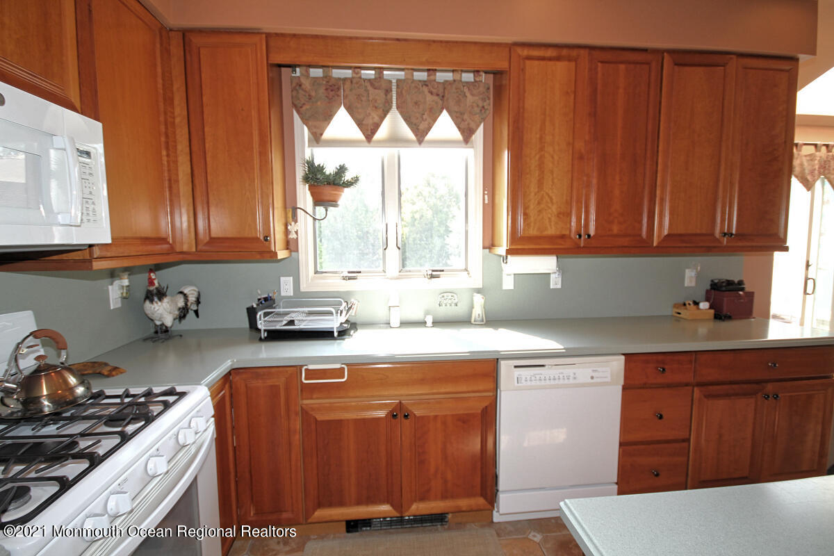 33 Maher Road Freehold, NJ 07728 - Photo 10 of 46 a kitchen with granite countertop wooden cabinets and a stove top oven