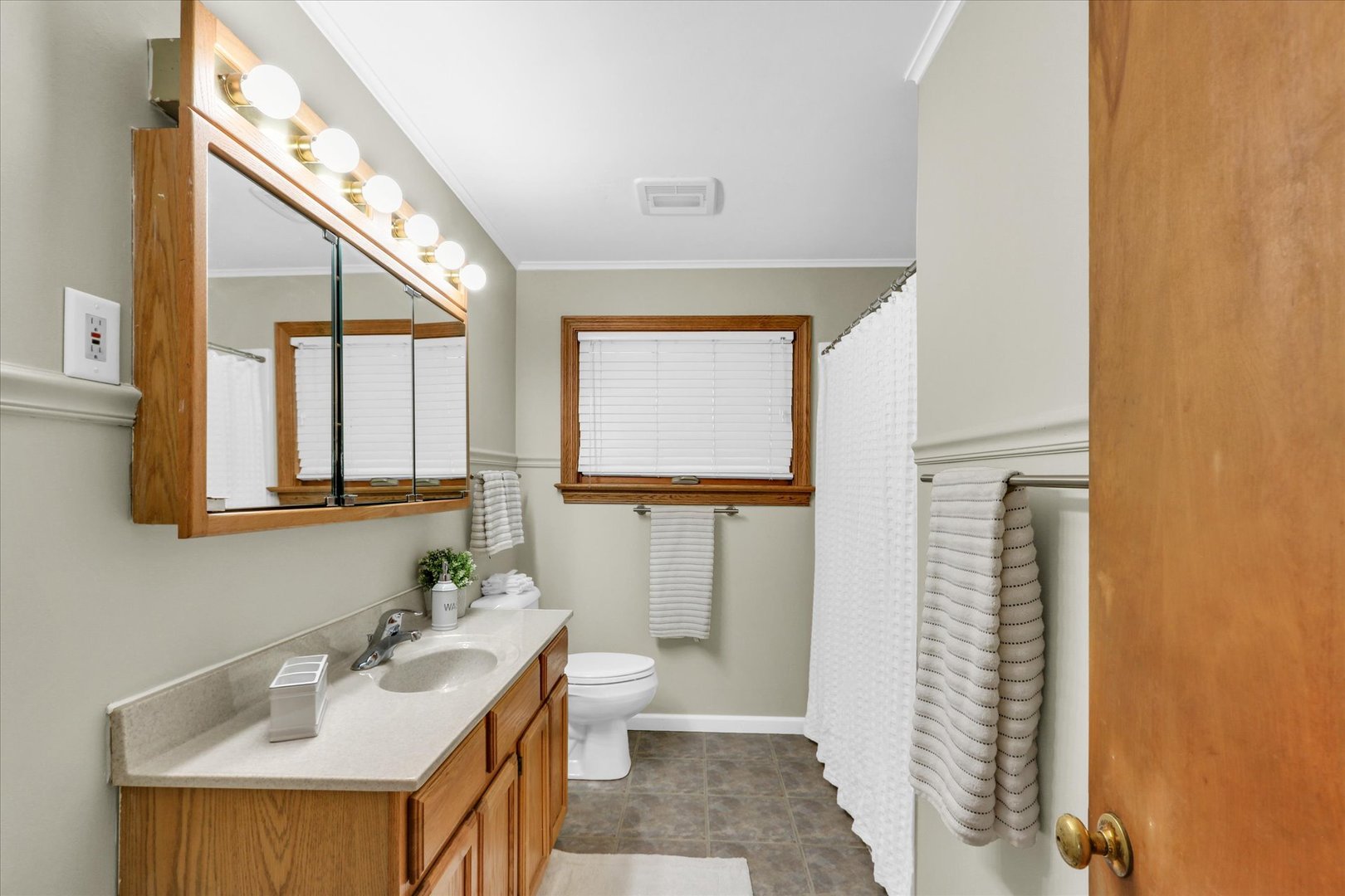 617 West John Street Champaign, IL 61820 - Photo 13 of 28 a bathroom with a sink a toilet and mirror