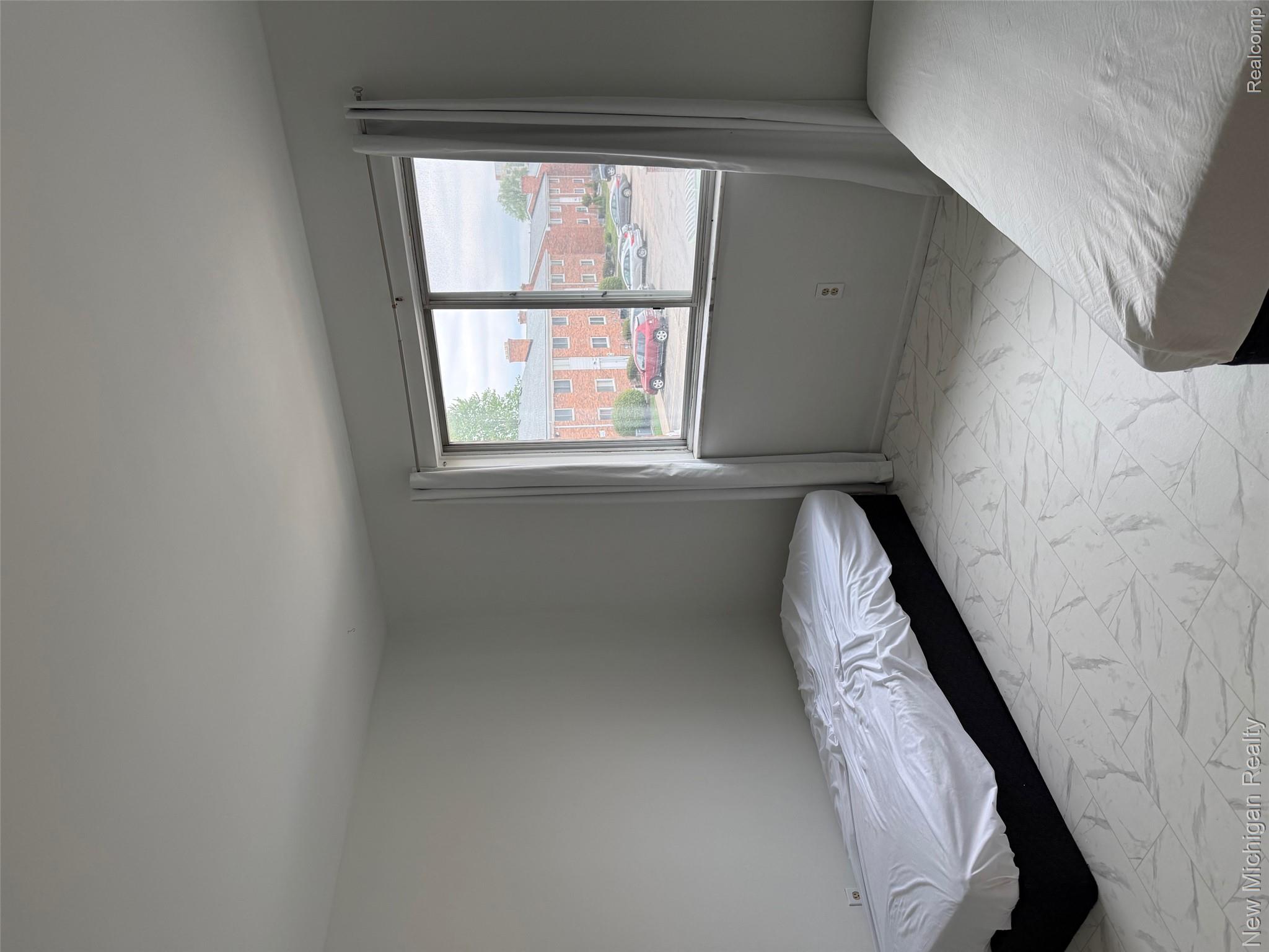 29276 Hoover Road, Unit 276 Warren, MI 48093 - Photo 13 of 14 Neutral white walls, white-framed window, and patterned tile flooring