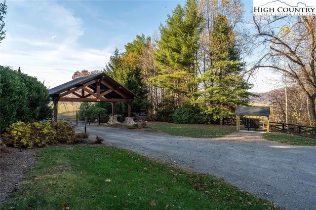 a view of a big house with a big yard and large trees