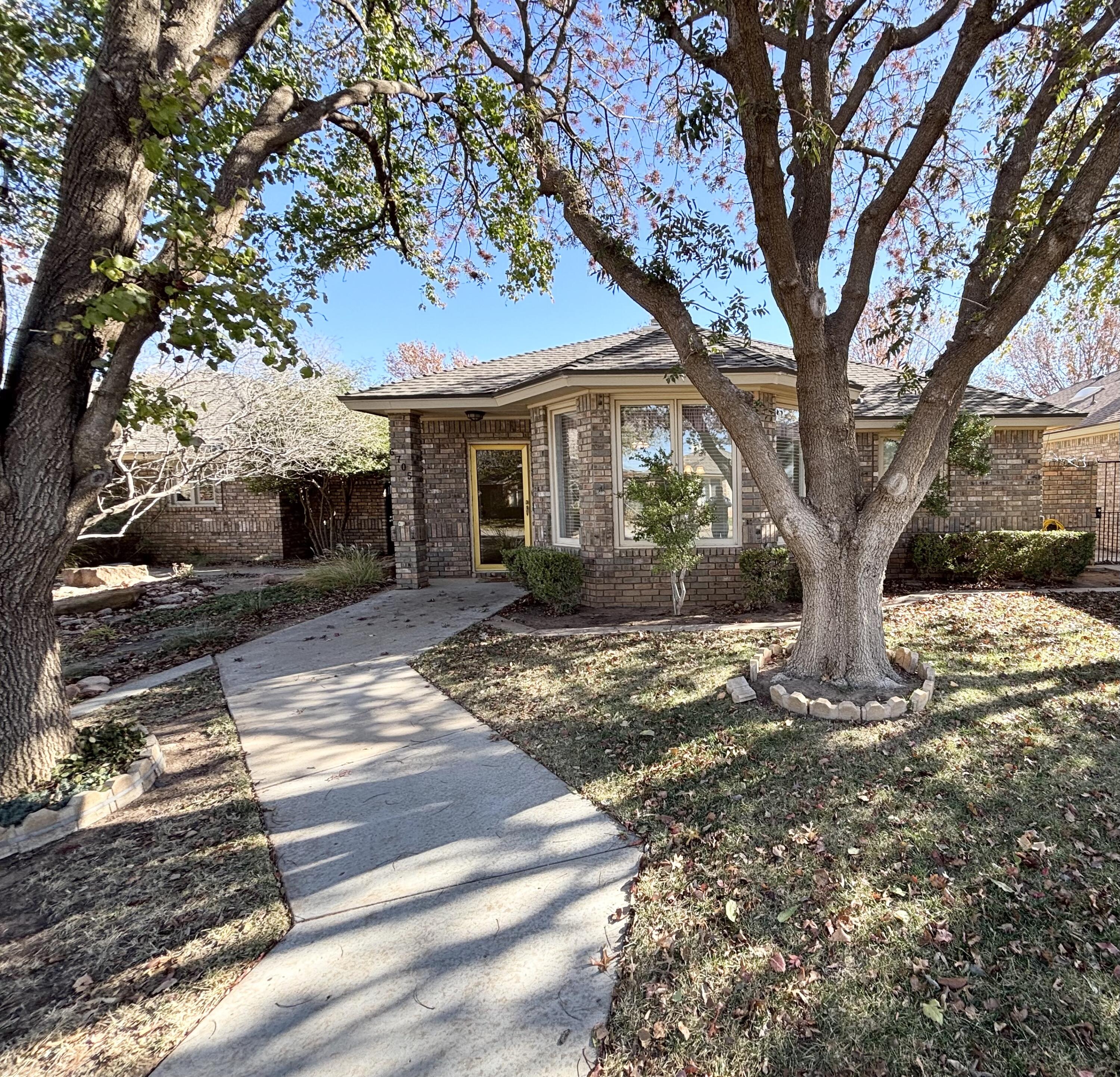 a view of a yard in front of a house with large tree