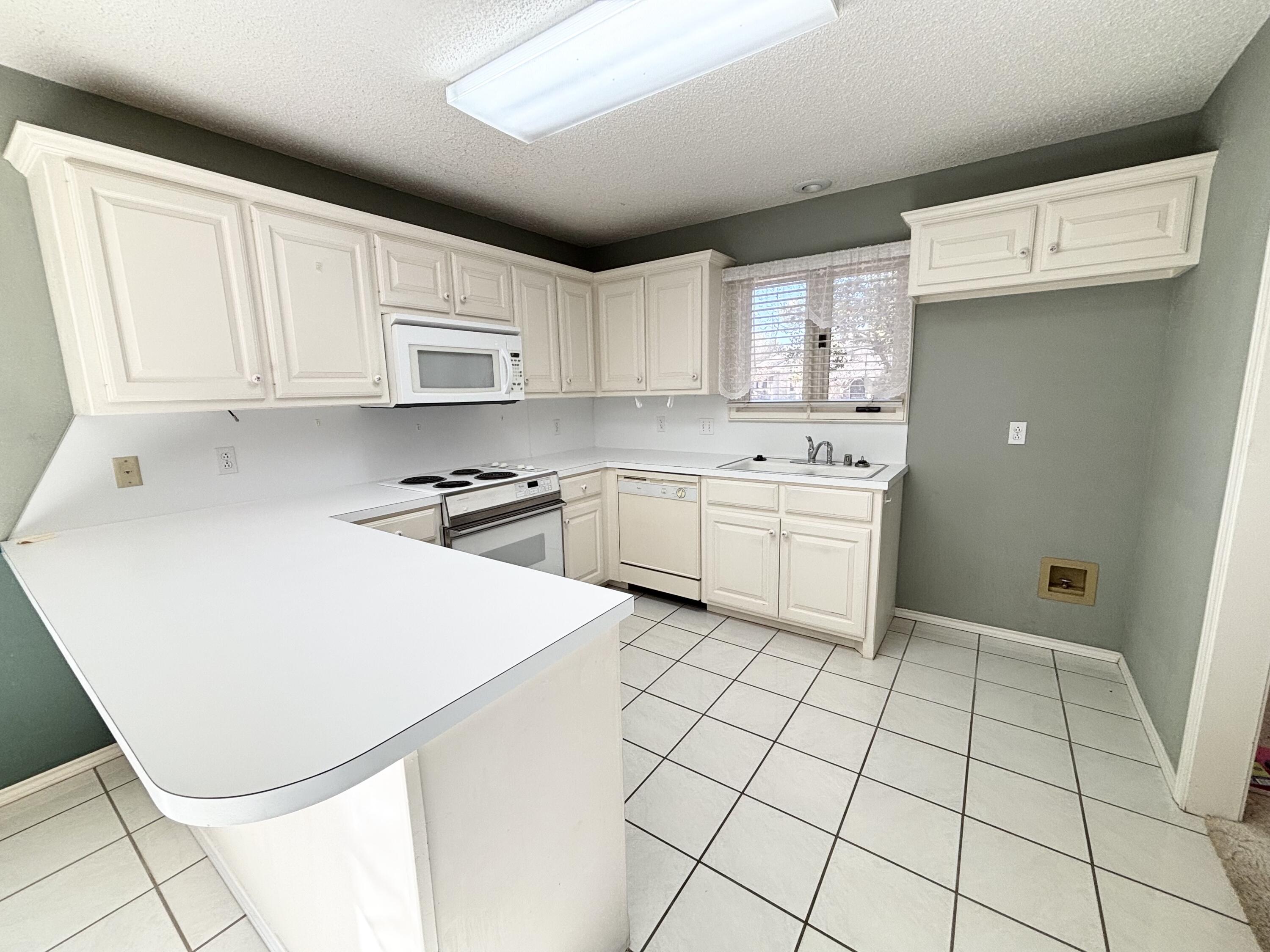 6705 Fulton Avenue Lubbock, TX 79424 - Photo 5 of 18 a kitchen with a stove a sink and a refrigerator