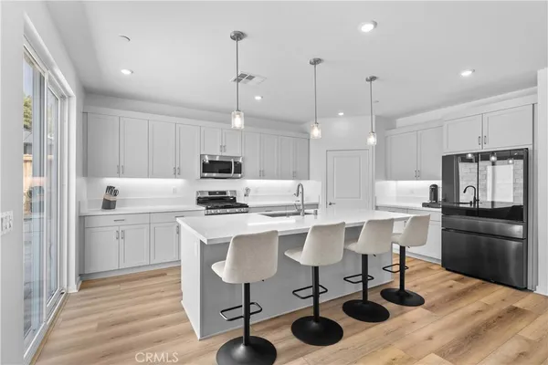 a kitchen with a sink a refrigerator and chairs