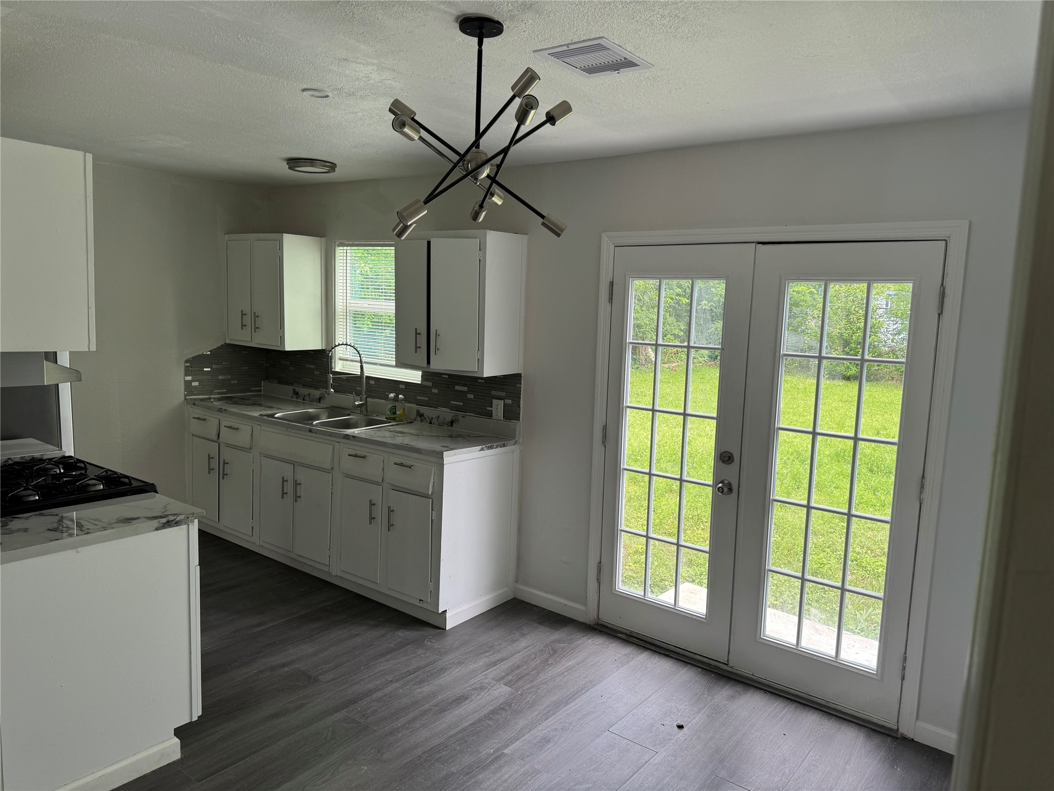 4215 Botany Lane Houston, TX 77047 - Photo 12 of 23 a kitchen with cabinets wooden floor and a fireplace