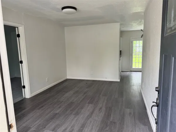 an empty room with wooden floor and a window