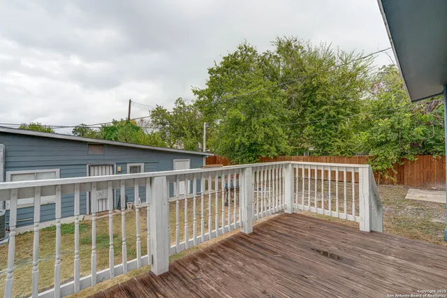 a balcony with wooden floor and fence