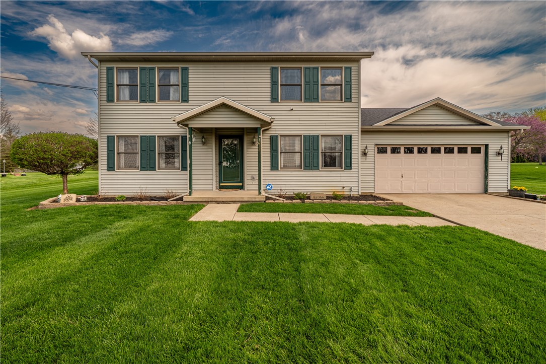This classic two-story residence features a well-maintained lawn and an attached garage.