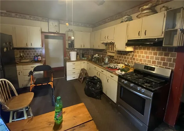 a kitchen with a stove a refrigerator and wooden cabinets