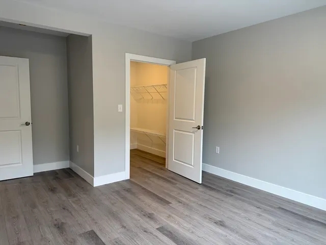 an empty room with wooden floor and closet