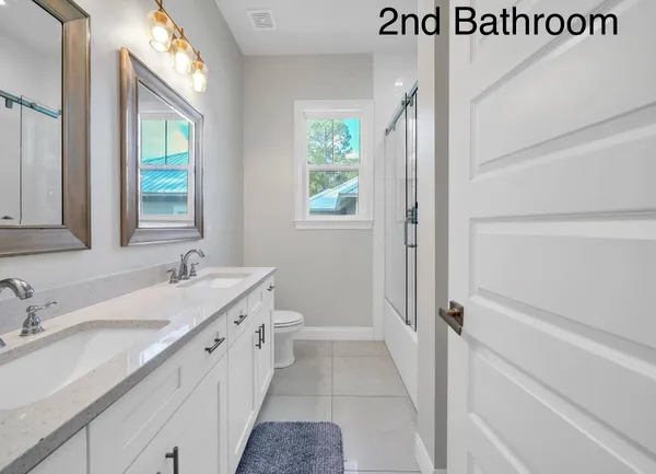 a bathroom with a double vanity sink a mirror and a bathtub