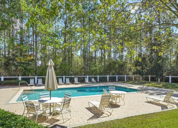 a view of swimming pool with table and chairs