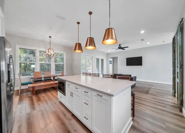 a kitchen with a stove a counter space a large window and furniture