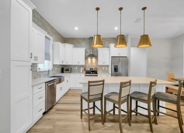 a view of kitchen with stainless steel appliances kitchen island granite countertop a table and chairs